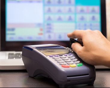 Point of sale hand swiping credit card at retail store